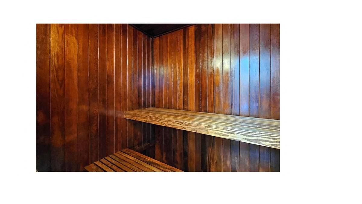 A wooden bench is placed in a wooden room.
